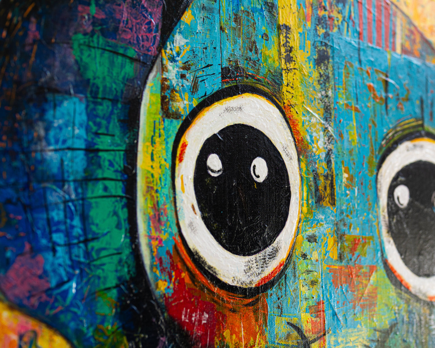 Close-up of a colorful abstract painting with prominent eyes.