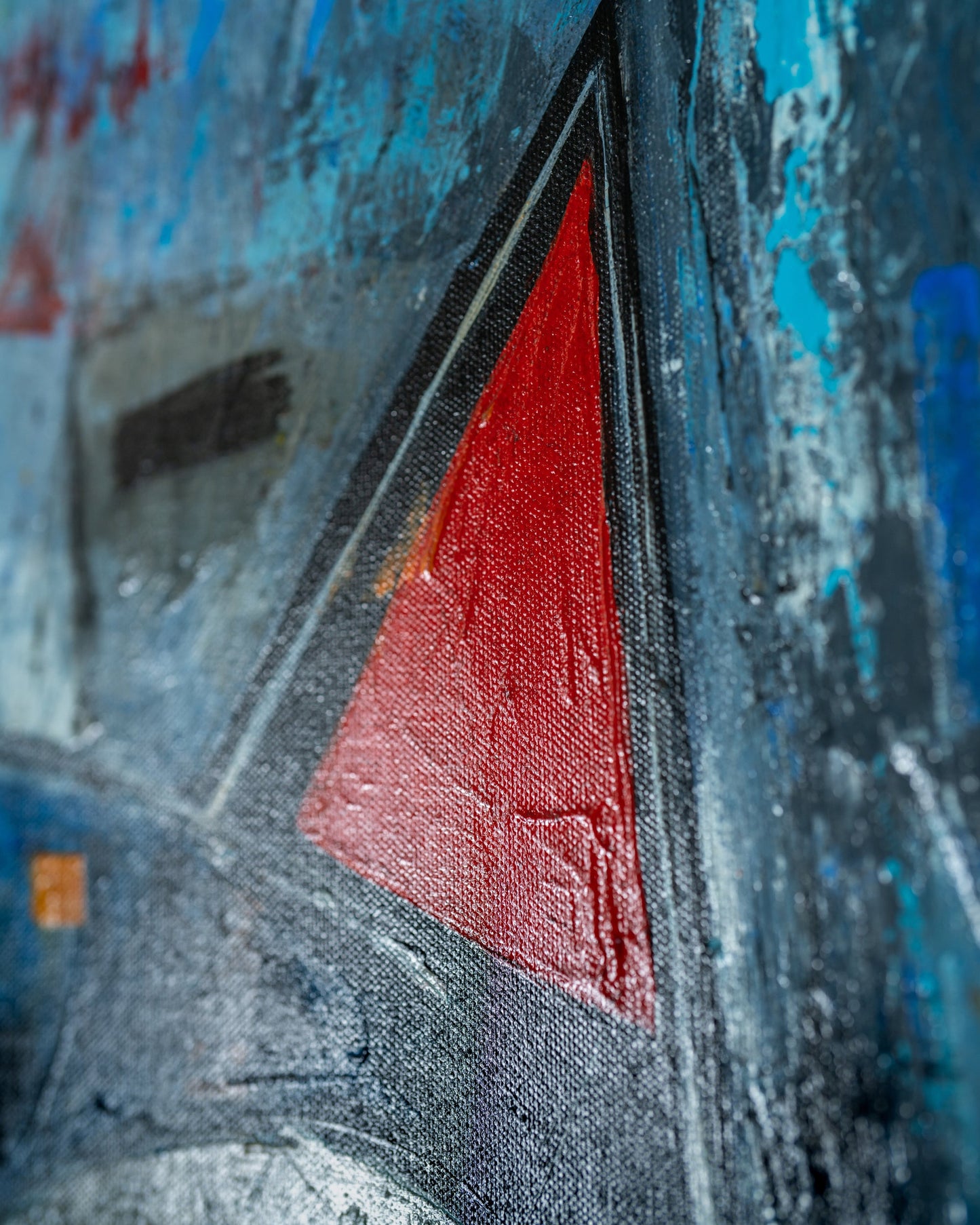Close-up of a textured surface with a red triangle and blue background