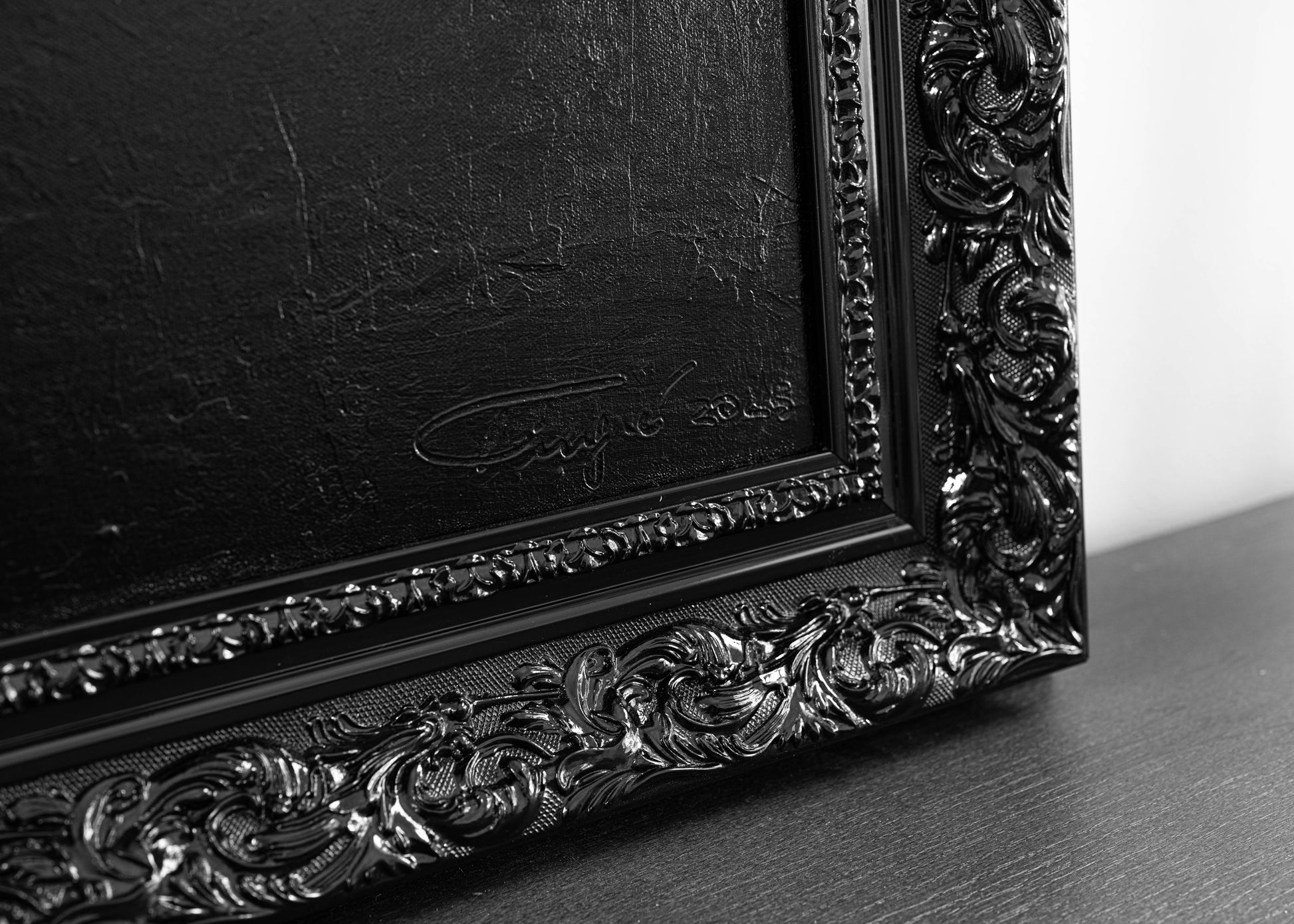 Decorative black frame with intricate detailing on a gray surface