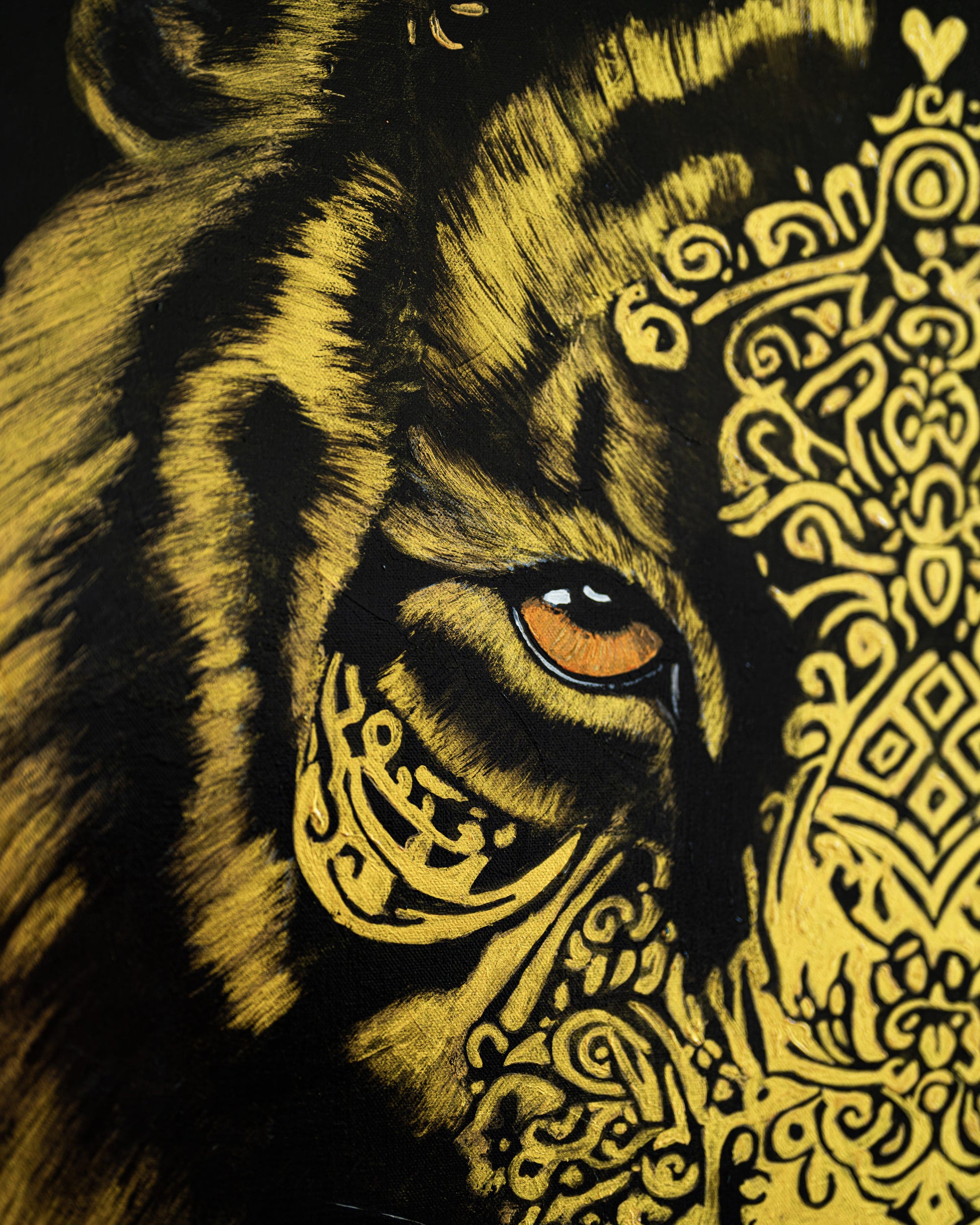 Close-up of a tiger's face with intricate gold patterns on a black background